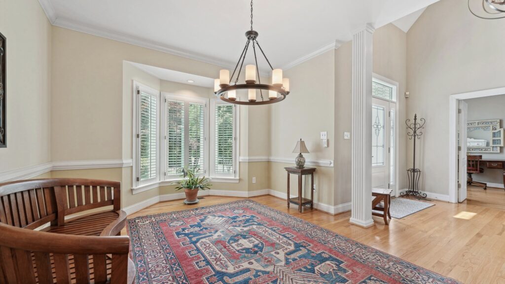 Two-story foyer and an expansive open floor plan drenched in natural light highlighting the beautiful hardwood floors that flow throughout the main level.