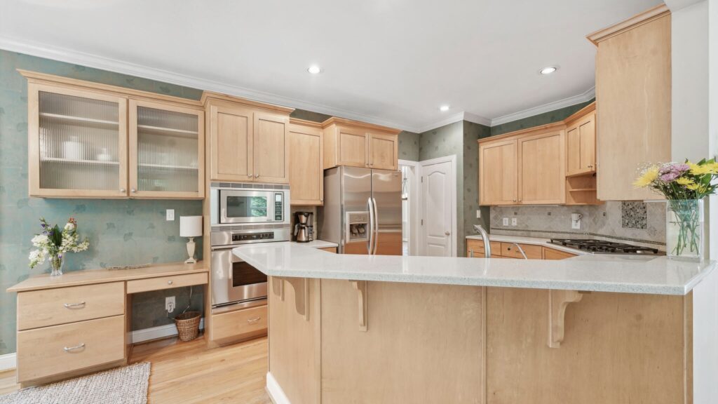 The heart of the home is the expansive Kitchen boasting ample Caesar stone countertops, tile backsplash, SS appliances, and abundant cabinetry complete with a desk/workspace. The Kitchen seamlessly connects to the large Family Room where dramatic oversized windows and a gas log fireplace create a warm and inviting atmosphere.