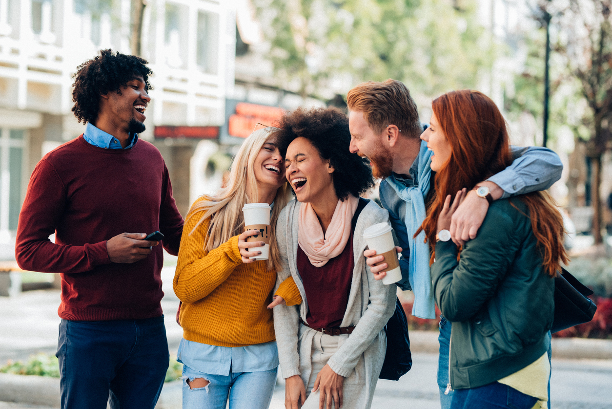 Group of multi-ethnic friends talking and laughing outdoor
